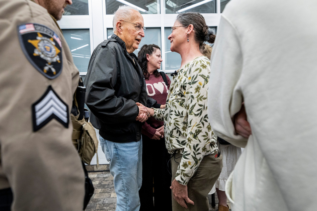 Brent Bullock, center left, who led investigations at the Utah County Attorney's Office around the time of Laura Ann Aime's murder, shakes hands with Michelle Impala, Aime's younger sister, after a news conference at the Utah County Sheriff's Office in Spanish Fork, Utah, Wednesday, April 1, 2026, announcing definitive evidence linking Ted Bundy to Aime's murder. (Isaac Hale/The Deseret News via AP)