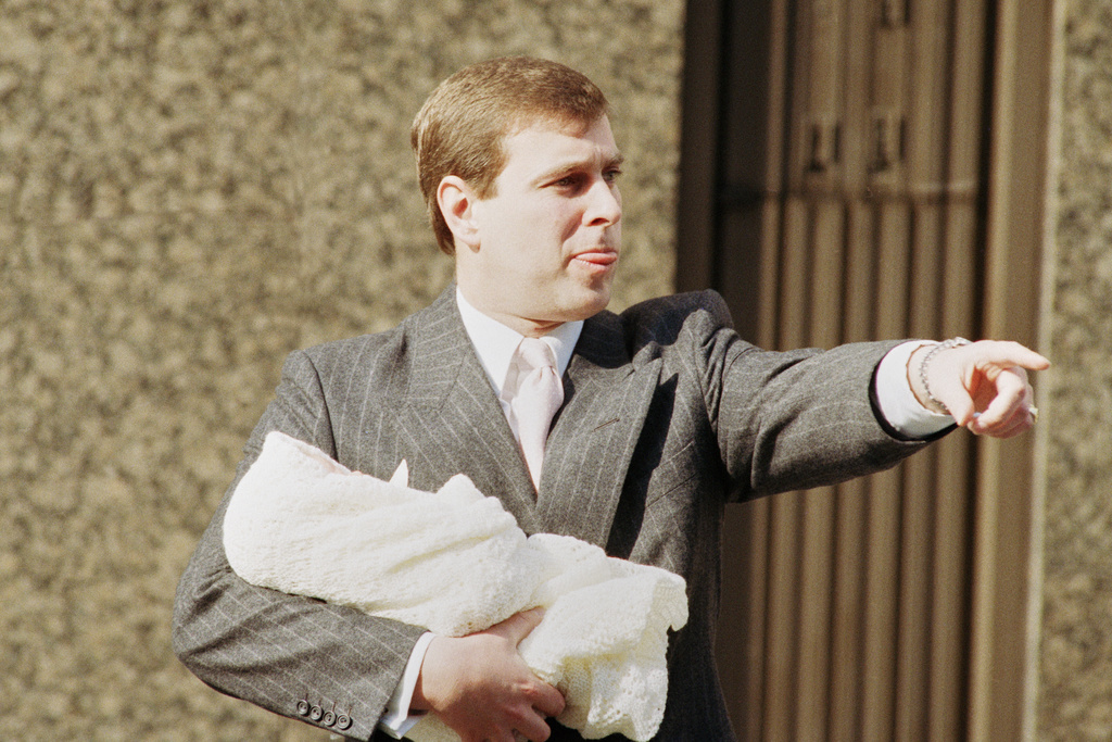FILE - The Duke of York holds week-old Princess Eugenie Victoria Helena outside Portland Hospital in London, March 30, 1990. (AP Photo/Peter Kemp, File)