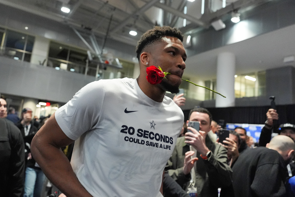 Milwaukee Bucks' Giannis Antetokounmpo walks with a rose in his mouth during the NBA All-Star basketball game media day Saturday, Feb. 14, 2026, in Inglewood, Calif. (AP Photo/Jae C. Hong)