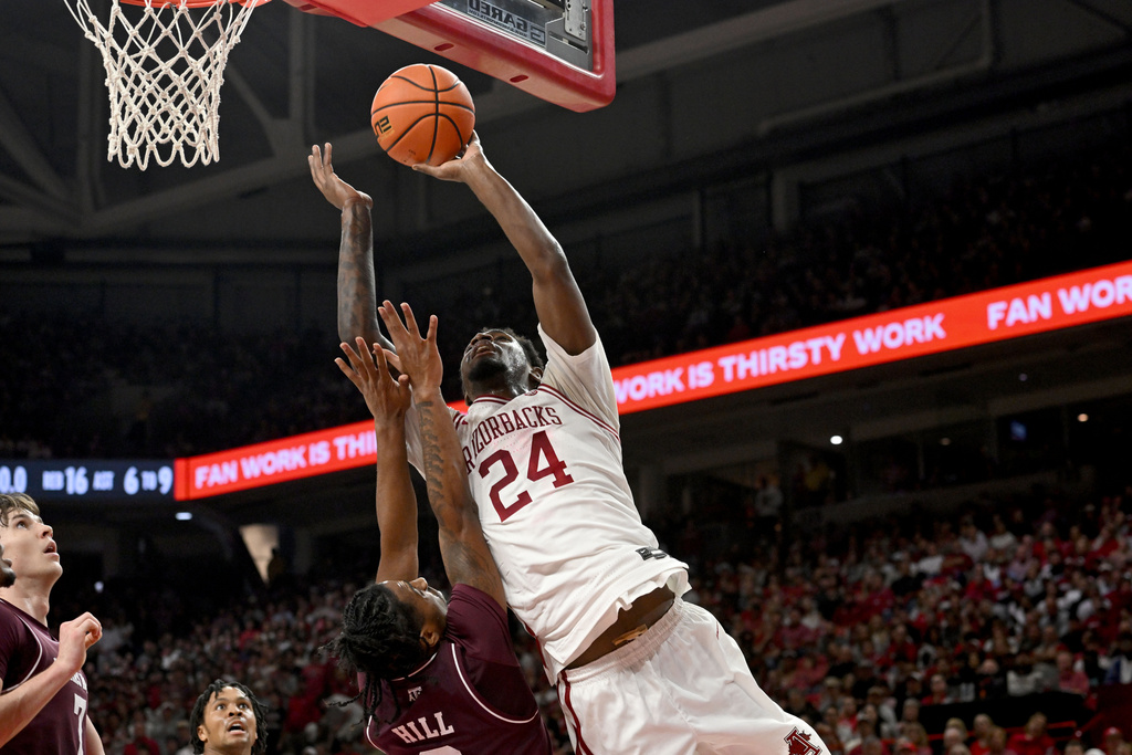 Arkansas guard Billy Richmond III shoots over Texas A&M guard Marcus Hill during an NCAA college basketball game, Wednesday, Feb. 25, 2026, in Fayetteville, Ark. (AP Photo/Michael Woods)