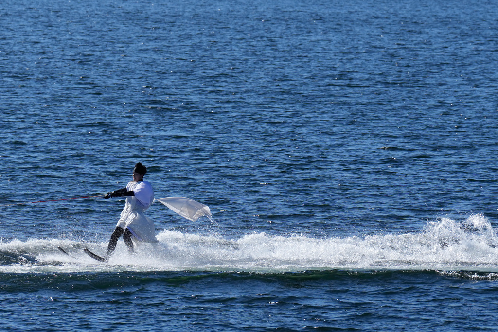 A student depicting a shrine priest skims across the water on water skis during the annual Bean Throwing Festival in Lake Ashi, near Hakone Shrine, Japan, Tuesday, Feb. 3, 2026. (AP Photo/Eugene Hoshiko)