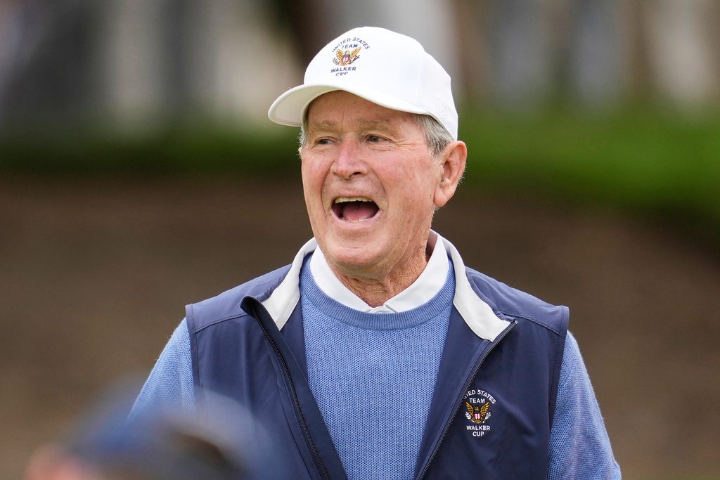 Former President George W. Bush reacts while watching players from the USA team practice before the Walker Cup golf matches against the Great Britain and Ireland team at Cypress Point Club in Pebble Beach, Calif., Friday, Sept. 5, 2025. (AP Photo/Jeff Chiu)