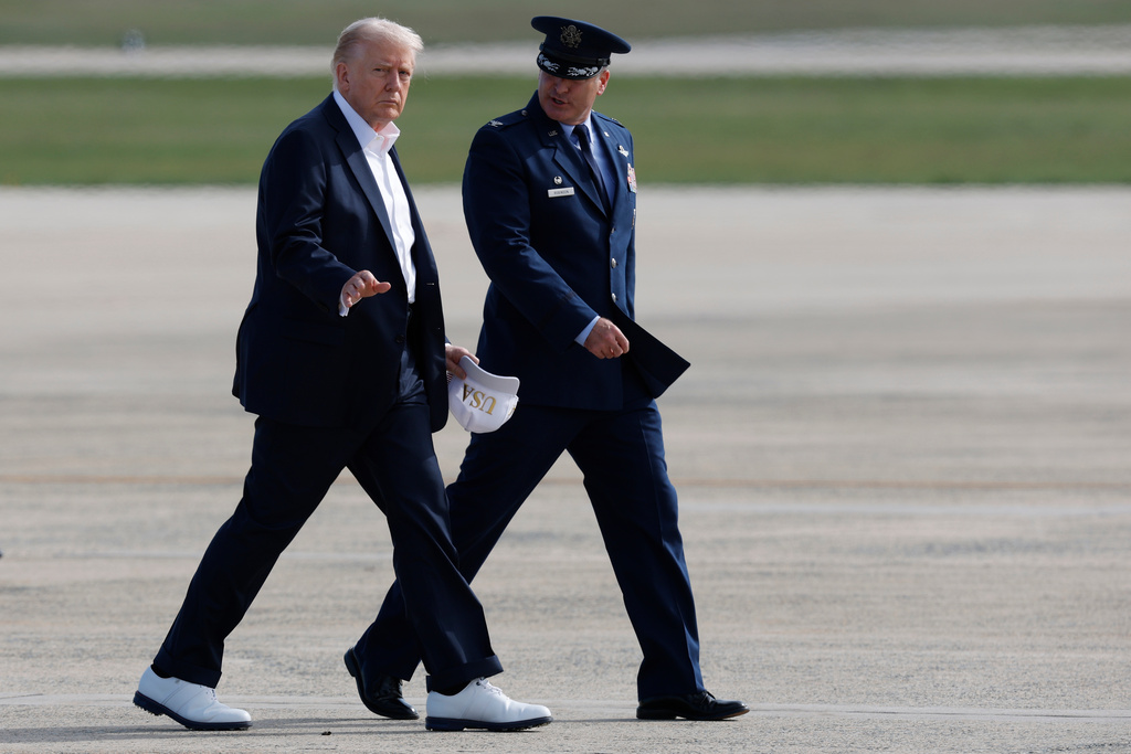 President Donald Trump waves as he is escorted by Air Force Col. Christopher M. Robinson, Commander, 89th Airlift Wing, before boarding Air Force One, Friday, Sept. 26, 2025, at Joint Base Andrews, Md., en route to the Ryder Cup golf tournament at Bethpage Black in Farmingdale, N.Y.(AP Photo/Luis M. Alvarez)