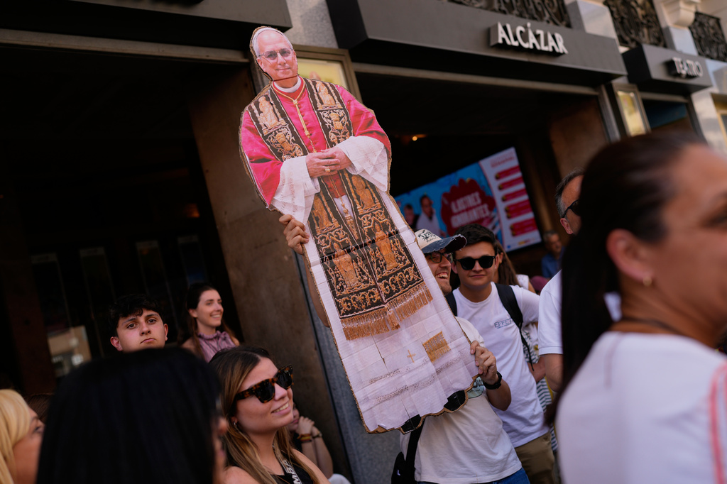 A man holds a portrait of Pope Leo XIV during a Mass marking the Catholic feast of Corpus Christi at Plaza de Cibeles in Madrid, Spain, Sunday, June 7, 2026, on the second day of his seven-day apostolic visit to mainland Spain and the Canary Islands. (AP Photo/Bernat Armangue)