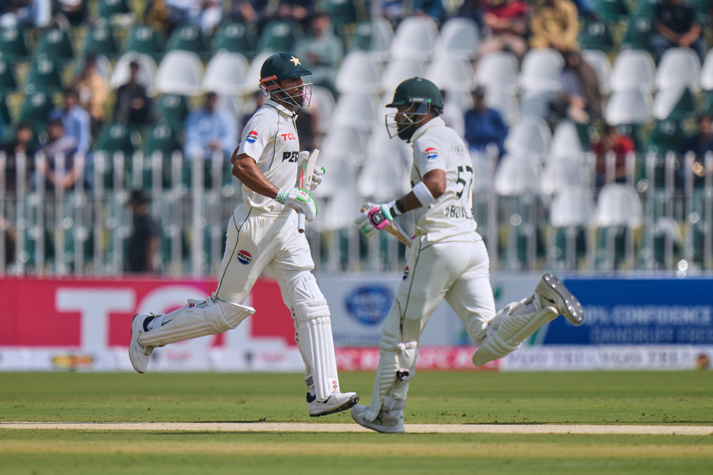 Pakistan's Shan Masood, left, Abdullah Shafique run between the wickets during the first day of the second test cricket match between Pakistan and South Africa, at the Rawalpindi Cricket Stadium, in Rawalpindi, Pakistan, Monday, Oct. 20, 2025. (AP Photo/Anjum Naveed)