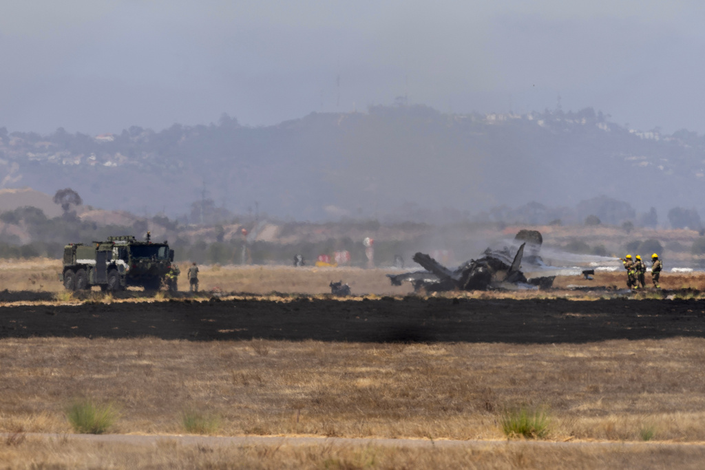 Crews work to douse a F-35 fighter jet that crashed near the run way at Marine Corps Air Station Miramar on Friday, July 31, 2026, in San Diego. (Luke Johnson/The San Diego Union-Tribune via AP)