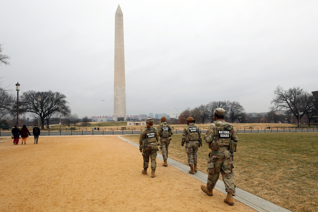 National Guard members patrol the Washington Mall, with the Washington Monument in the background, Friday, Jan. 9, 2026, in Washington. (AP Photo/Rahmat Gul)