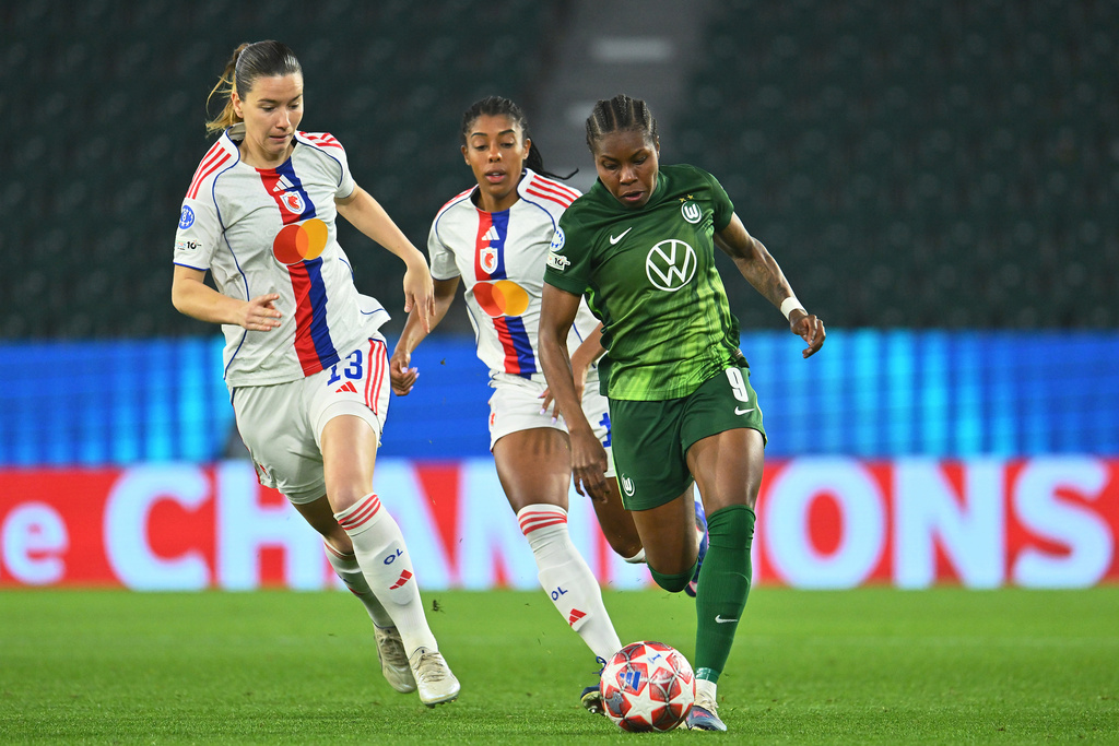 Wolfburg's Lineth Beerensteyn, right, dribbles past Lyon's Damaris Egurrola during their Champions League quarter-finals, first leg soccer match in Wolfsburg, Germany, Tuesday, March 24, 2026. (Swen Pfortner/dpa via AP)