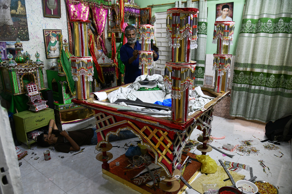 Raju Rathore, an artisan from Pakistani Hindu community, makes a replica of the mausoleum of Imam Hussain locally called 'Tazia', in preparation for the upcoming Ashoura, when Shiites Muslims mark the death of Hussein, at his home in Karachi, Pakistan, Tuesday, June 23, 2026. (AP Photo/Ali Raza)