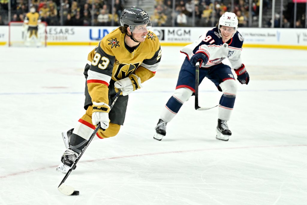 Vegas Golden Knights right wing Mitch Marner (93) handles the puck against Columbus Blue Jackets center Kent Johnson (91) during the second period of an NHL hockey game Thursday, Jan. 8, 2026, in Las Vegas. (AP Photo/David Becker)