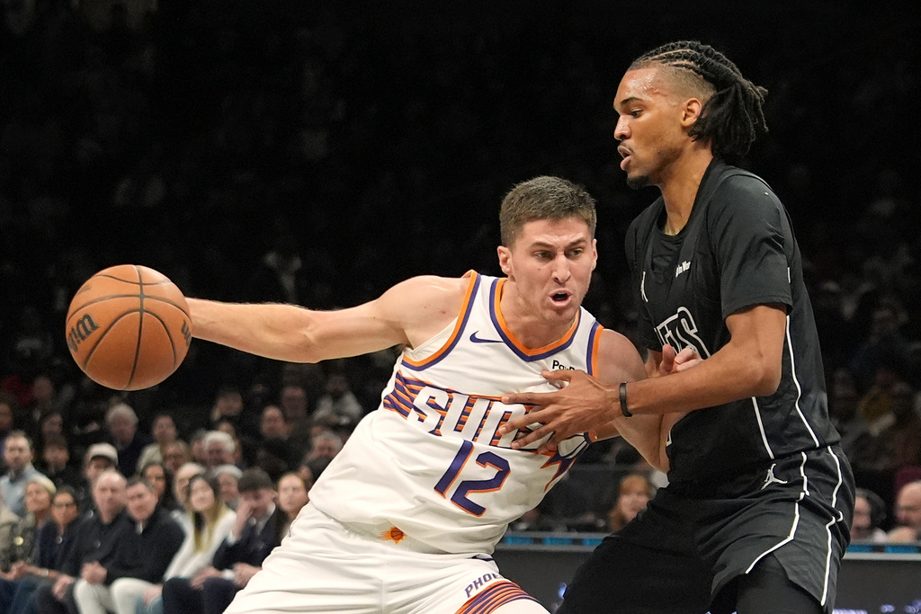 Brooklyn Nets' Ziaire Williams, right, defends Phoenix Suns' Collin Gillespie during the first half of an NBA basketball game Monday, Jan. 19, 2026, in New York. (AP Photo/Frank Franklin II)