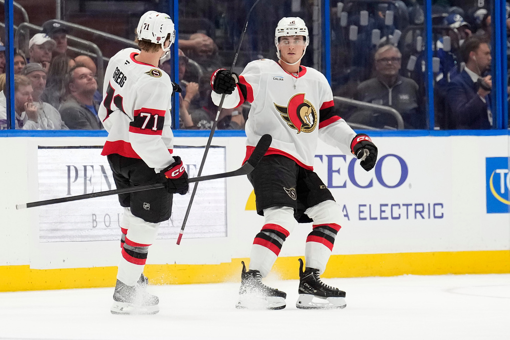 Ottawa Senators center Shane Pinto (12) celebrates his goal against the Tampa Bay Lightning with center Ridly Greig (71) during the second period of an NHL hockey game Thursday, Oct. 9, 2025, in Tampa, Fla. (AP Photo/Chris O'Meara)