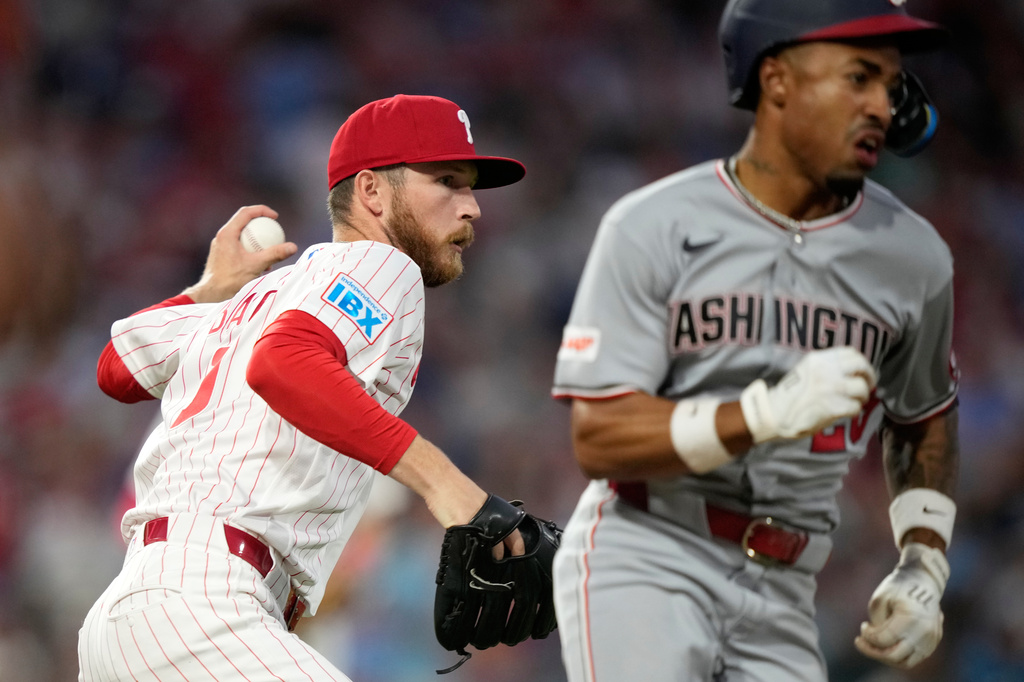 Philadelphia Phillies pitcher Kyle Backhus, left, throws to first after fielding a bunt by Washington Nationals' Nasim Nuñez during the seventh inning of a baseball game Monday, Aug. 3, 2026, in Philadelphia. (AP Photo/Matt Slocum)