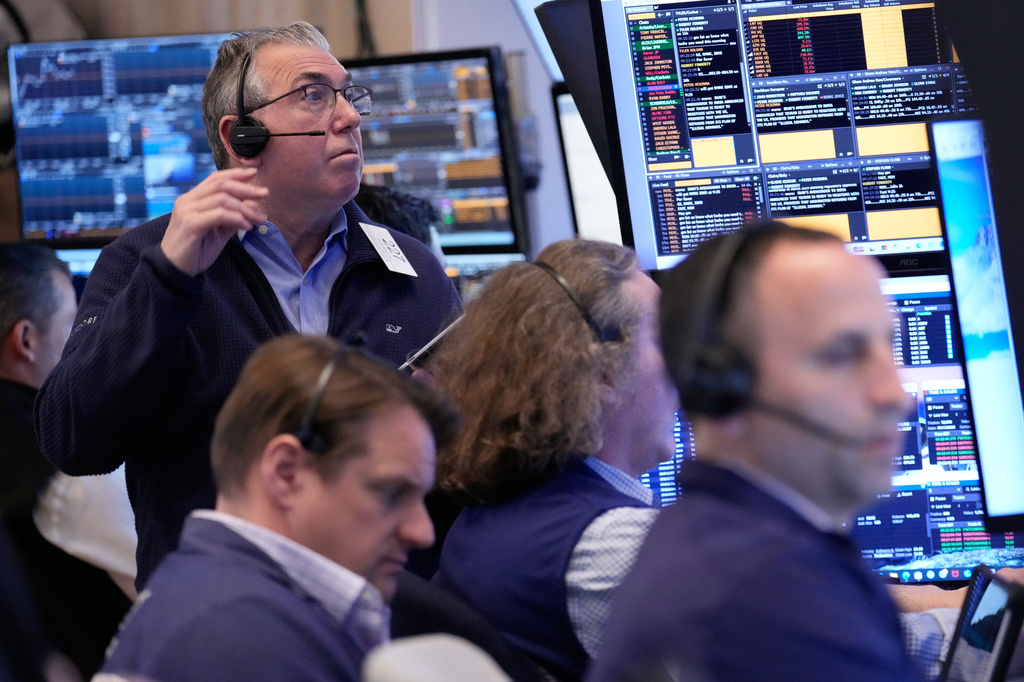 John Bishop, left, and others work on the floor at the New York Stock Exchange in New York, Monday, April 13, 2026. (AP Photo/Seth Wenig)