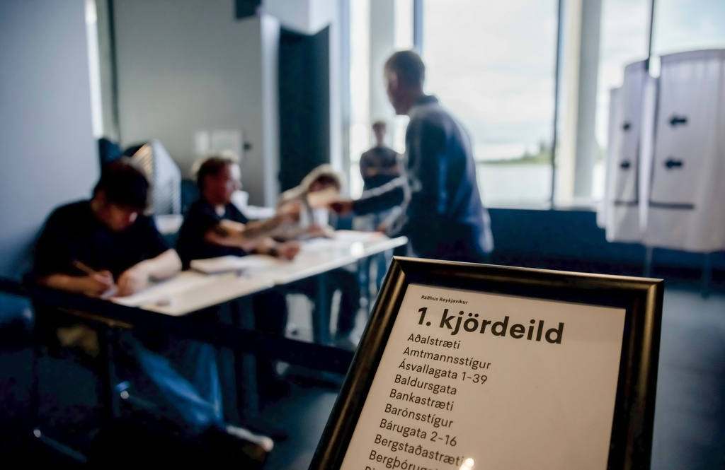 Election officials assist a voter at a polling station inside Reykjavik City Hall in Reykjavik, Iceland, Saturday, Aug. 29, 2026. (AP Photo/Marco Di Marco)