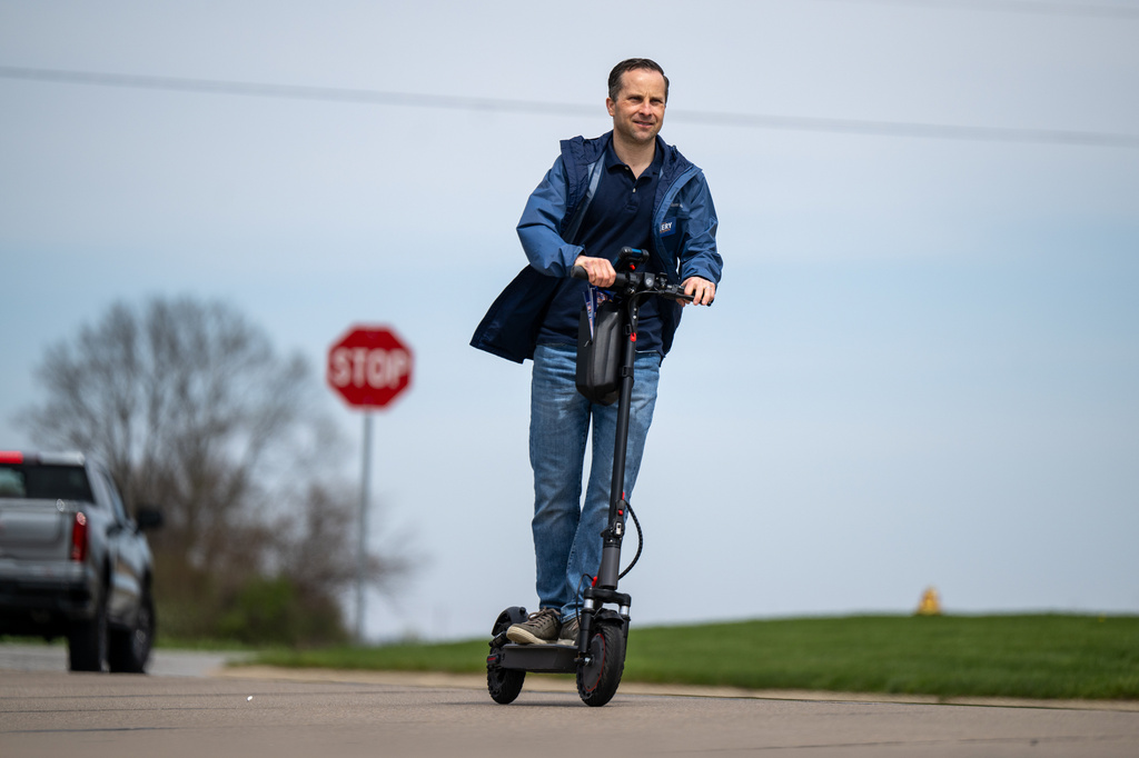 Indiana state Sen. Spencer Deery, R-West Lafayette, who represents District 23, canvasses a neighborhood on an electric scooter, Saturday, April 11, 2026, in West Lafayette, Ind. (AP Photo/Doug McSchooler)