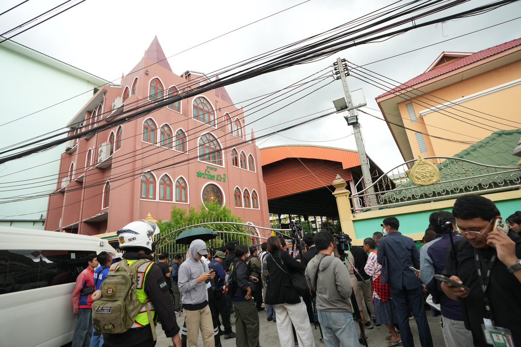 A crowd gathers outside a school where deaths and injuries were reported after a shooting in Thailand's Nonthaburi province, Friday, Aug. 7, 2026. (AP Photo/Sakchai Lalit)