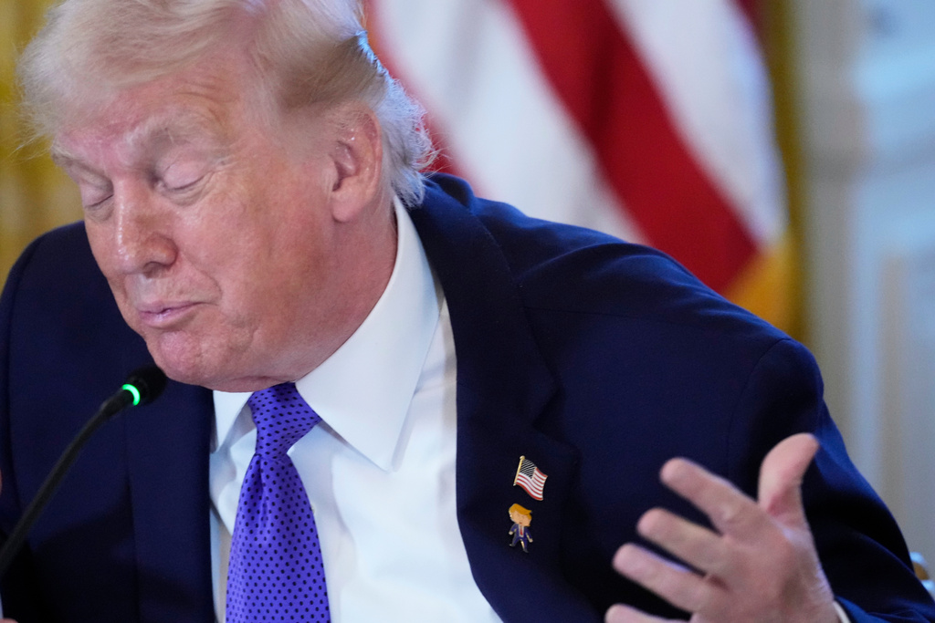 President Donald Trump wears a gift, which he calls a "Happy Trump" pin, during a meeting with oil executives in the East Room of the White House, Friday, Jan. 9, 2026, in Washington. (AP Photo/Alex Brandon)