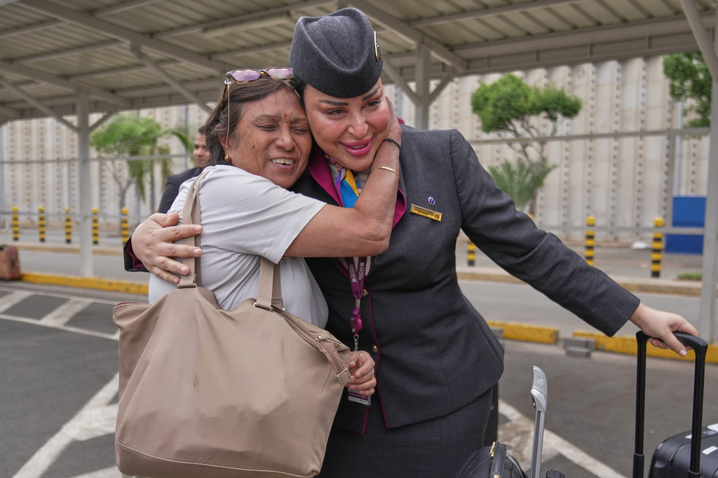 A passenger hugs a Qatar Airways flight attendant after a delayed flight was cleared for departure during a workers strike at Jomo Kenyatta International Airport, in Nairobi, Kenya, Monday, Aug. 31, 2026. (AP Photo/Brian Inganga)