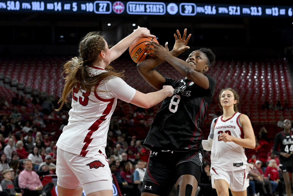 South Carolina forward Joyce Edwards (8) is fouled as she tries to drive past Arkansas guard Emily Robinson (23) during the first half of an NCAA college basketball game Thursday, Jan. 8, 2026, in Fayetteville, Ark. (AP Photo/Michael Woods)
