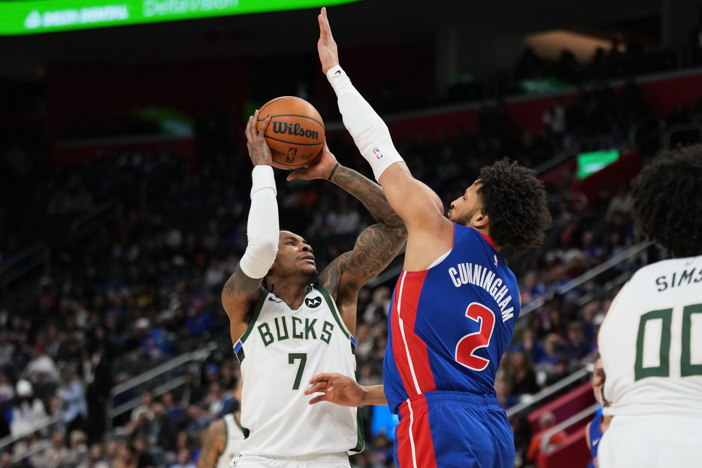 Milwaukee Bucks guard Kevin Porter Jr., left, shoots against Detroit Pistons guard Cade Cunningham during the first half of an NBA basketball game, Saturday, Dec. 6, 2025, in Detroit. (AP Photo/Ryan Sun)