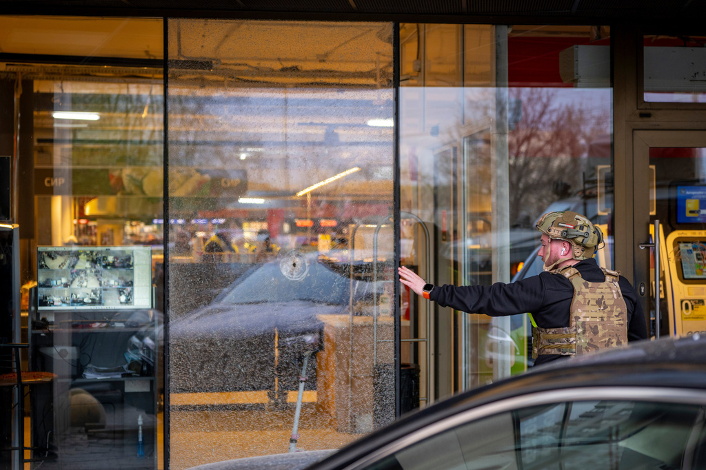 A police officer inspects the site where a gunman killed at least six people in the streets before being shot dead by police, in Kyiv, Ukraine, Saturday, April 18, 2026. (AP Photo/Dan Bashakov)