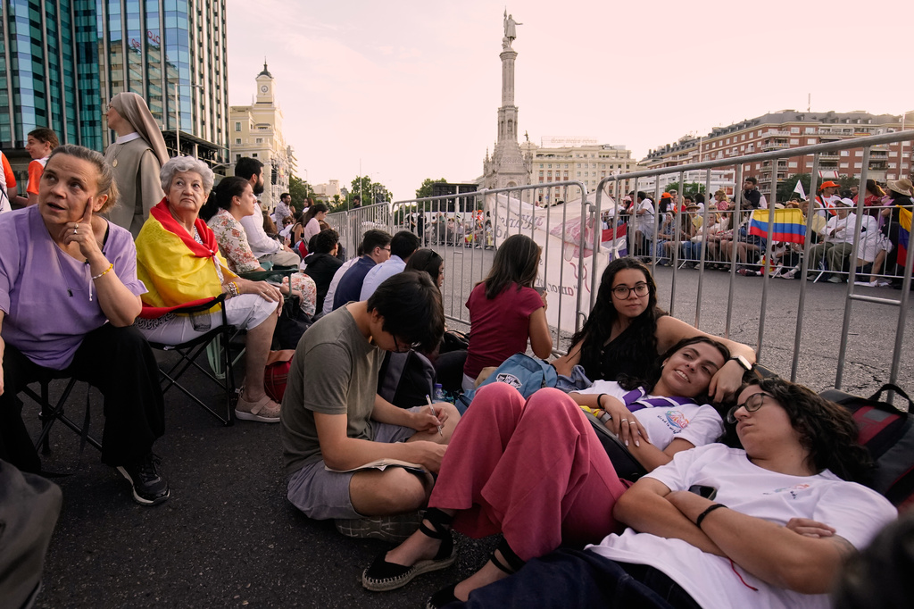 People wait for the arrival of Pope Leo XIV ahead of a Holy Mass and Corpus Christi procession at Plaza de Cibeles in Madrid, Spain, Sunday, June 7, 2026, on the second day of his seven-day apostolic visit to mainland Spain and the Canary Islands. (AP Photo/Andrea Comas)