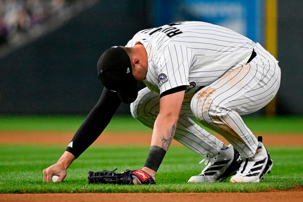 Colorado Rockies first baseman TJ Rumfield reacts after committing a fielding error in the seventh inning of a baseball game against the Miami Marlins Tuesday, June 30, 2026, in Denver. (AP Photo/Geneva Heffernan)