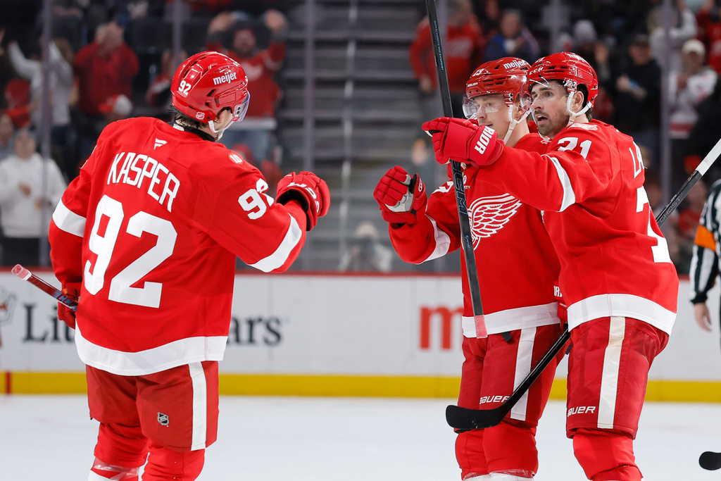 Detroit Red Wings center Marco Kasper (92) celebrates with left wing Lucas Raymond, center, and center Dylan Larkin, right, after Kasper's open-net goal against the San Jose Sharks during the third period of an NHL hockey game Friday, Jan. 16, 2026, in Detroit. (AP Photo/Duane Burleson)