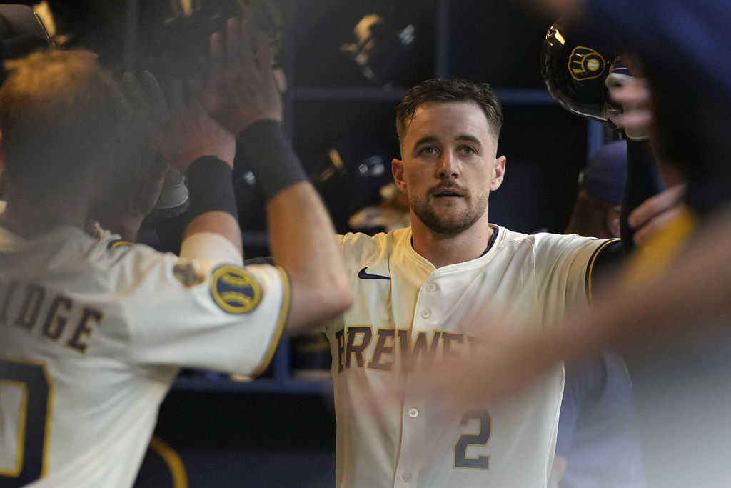 Milwaukee Brewers' Brice Turang is congratulated in the dugout after hitting a solo home run during the first inning of a baseball game against the Pittsburgh Pirates, Monday, Aug. 11, 2025, in Milwaukee. (AP Photo/Aaron Gash)