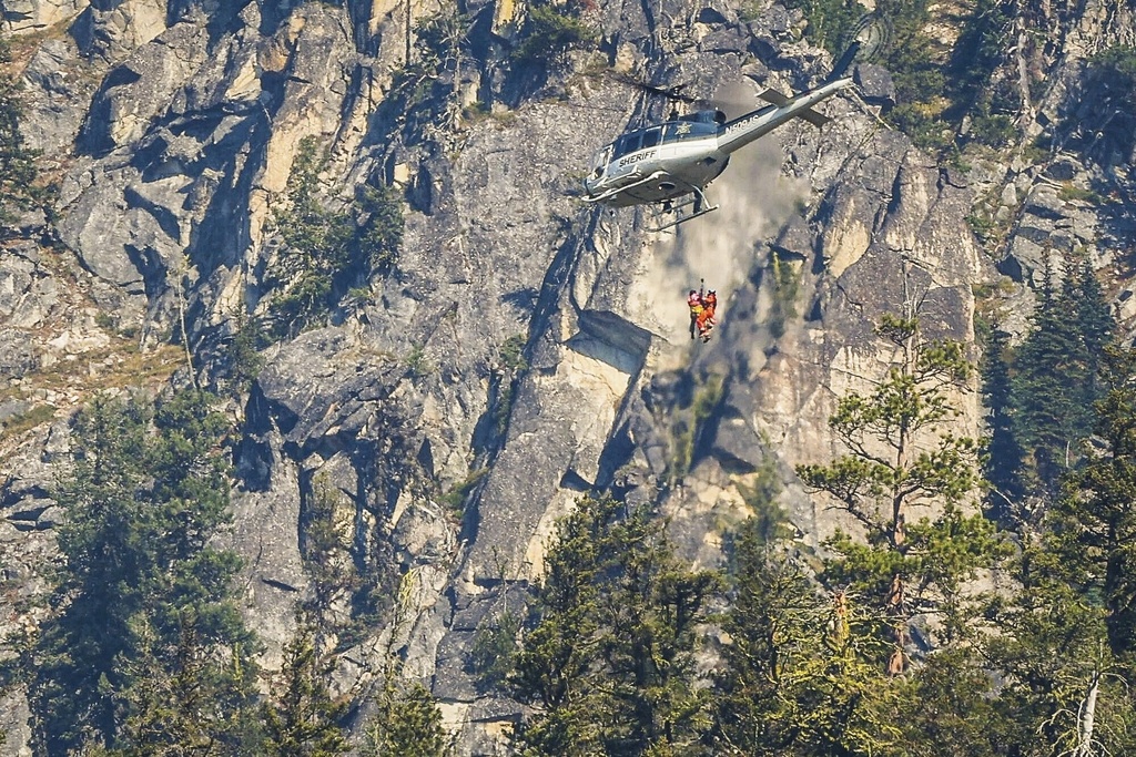 Authorities rappel from a Spokane County Sheriff Office helicopter to the site where human remains believed to be Travis Decker's were found yesterday near Grindstone Mountain, seen on Friday, Sept. 19, 2025, near Leavenworth, Wash. (Nick Wagner/The Seattle Times via AP)