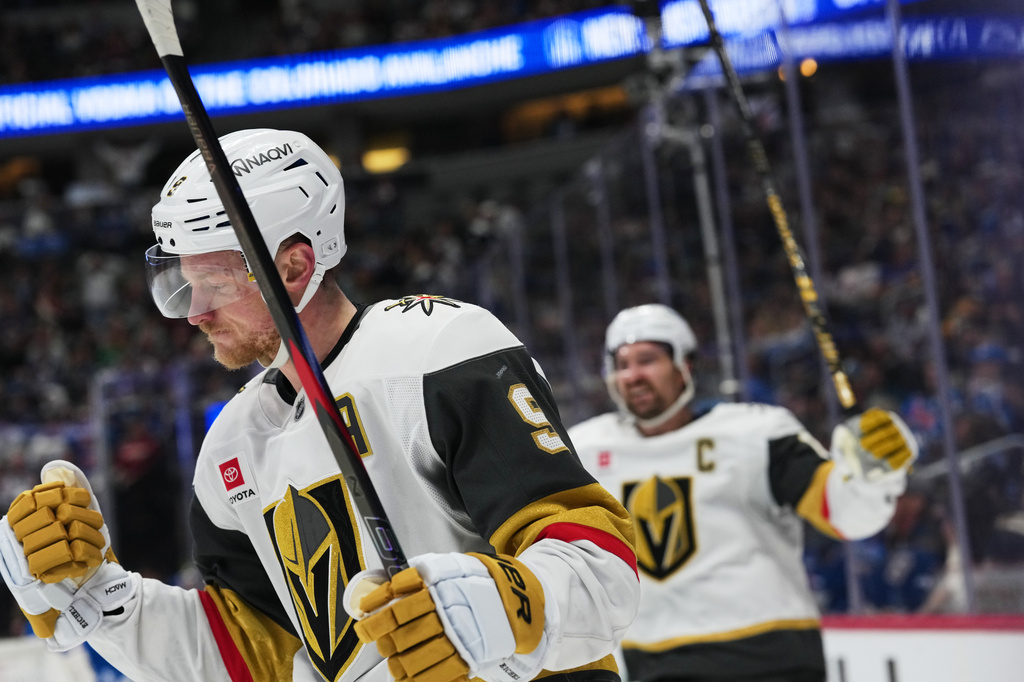 Vegas Golden Knights center Jack Eichel, front, reacts after scoring the winning goal as right wing Mark Stone celebrates in overtime of an NHL hockey game against the Colorado Avalanche Saturday, April 11, 2026, in Denver. (AP Photo/David Zalubowski)