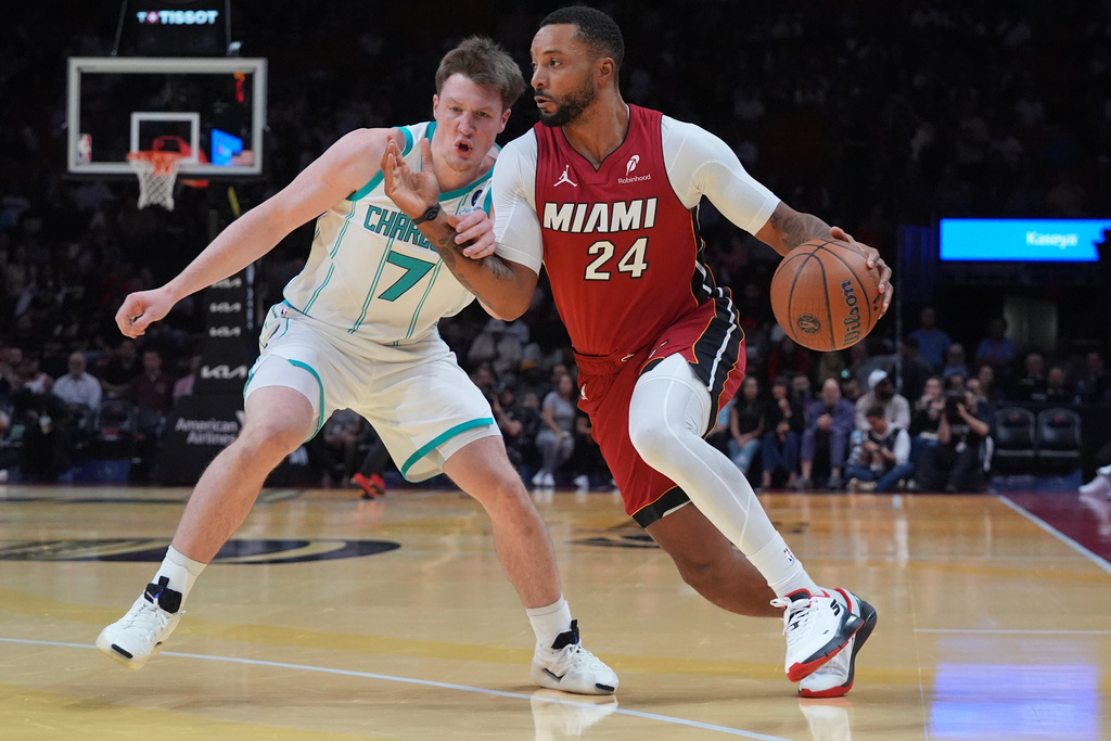 Miami Heat guard Norman Powell (24) drives to the basket as Charlotte Hornets guard Kon Knueppel (7) defends during the first half of an NBA Cup basketball game Friday, Nov. 7, 2025, in Miami. (AP Photo/Marta Lavandier)