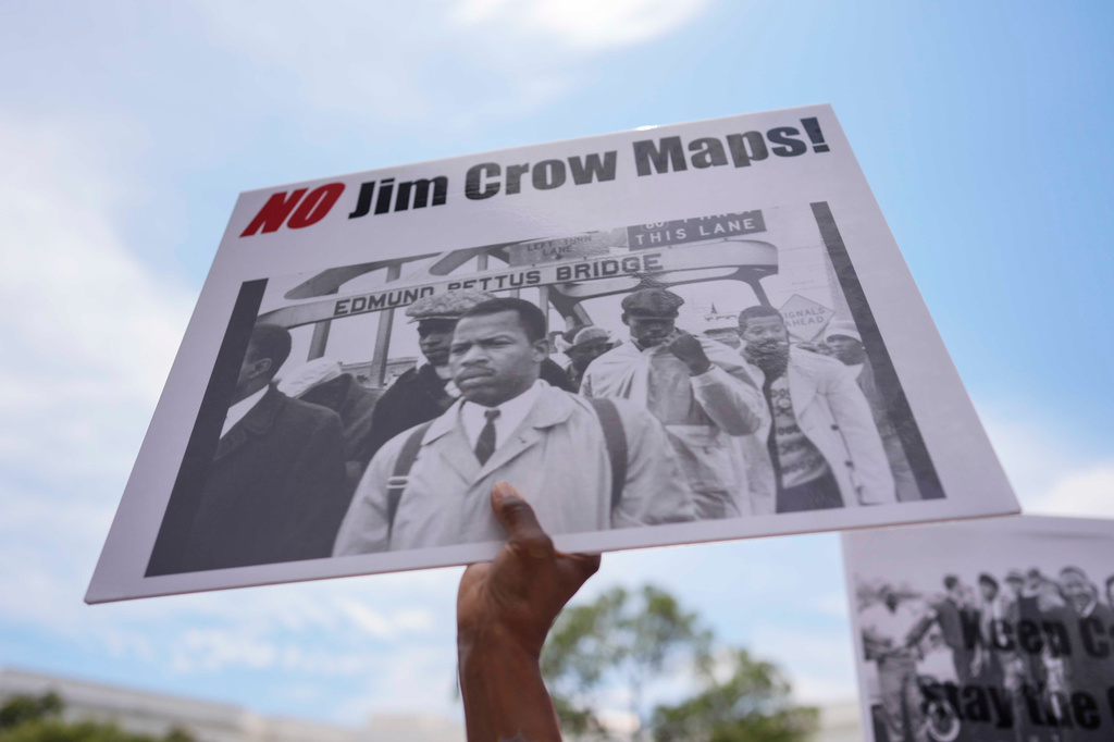 A protestor holds a sign of the late Georgia Congressman John Lewis during a voting rally, Saturday, May 16, 2026, in Montgomery, Ala. (AP Photo/Mike Stewart)