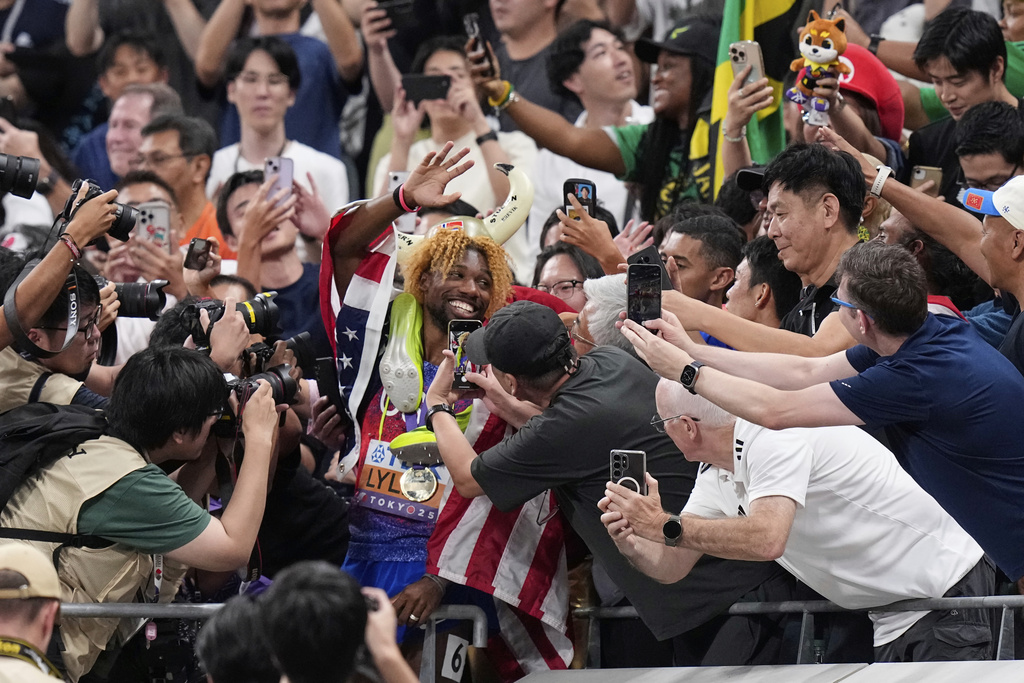 United States' Noah Lyles celebrates with his supporters after winning gold medal in the men's 200 meters final at the World Athletics Championships in Tokyo, Friday, Sept. 19, 2025. (AP Photo/Eugene Hoshiko)