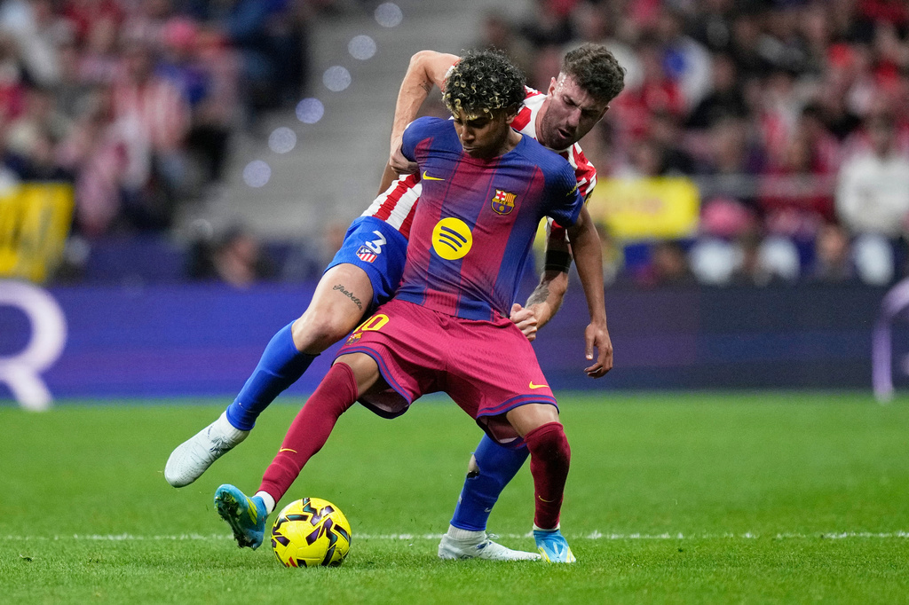 Barcelona's Lamine Yamal, front defends the ball from Atletico Madrid's Matteo Ruggeri during a La Liga soccer match between Atletico Madrid and Barcelona in Madrid, Spain, Saturday, April 4, 2026. (AP Photo/Bernat Armangue)