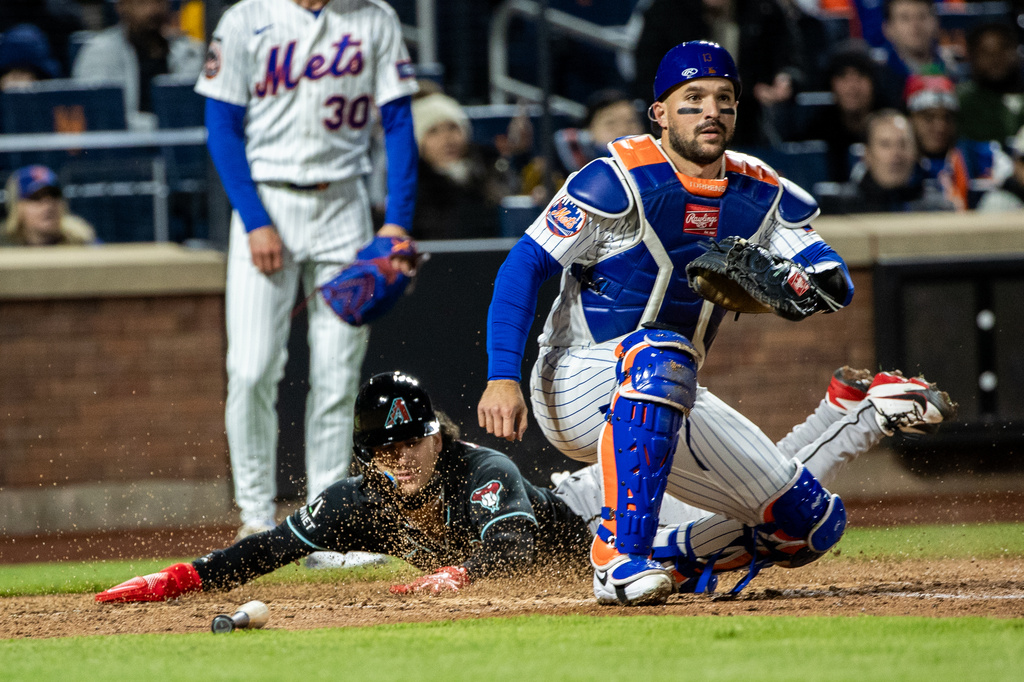 Arizona Diamondbacks' Alek Thomas (5) slides into home base and scores a run on Jorge Barrosa's triple during the seventh inning of a baseball game against the New York Mets, Thursday, April 9, 2026, in New York. (AP Photo/Angelina Katsanis)