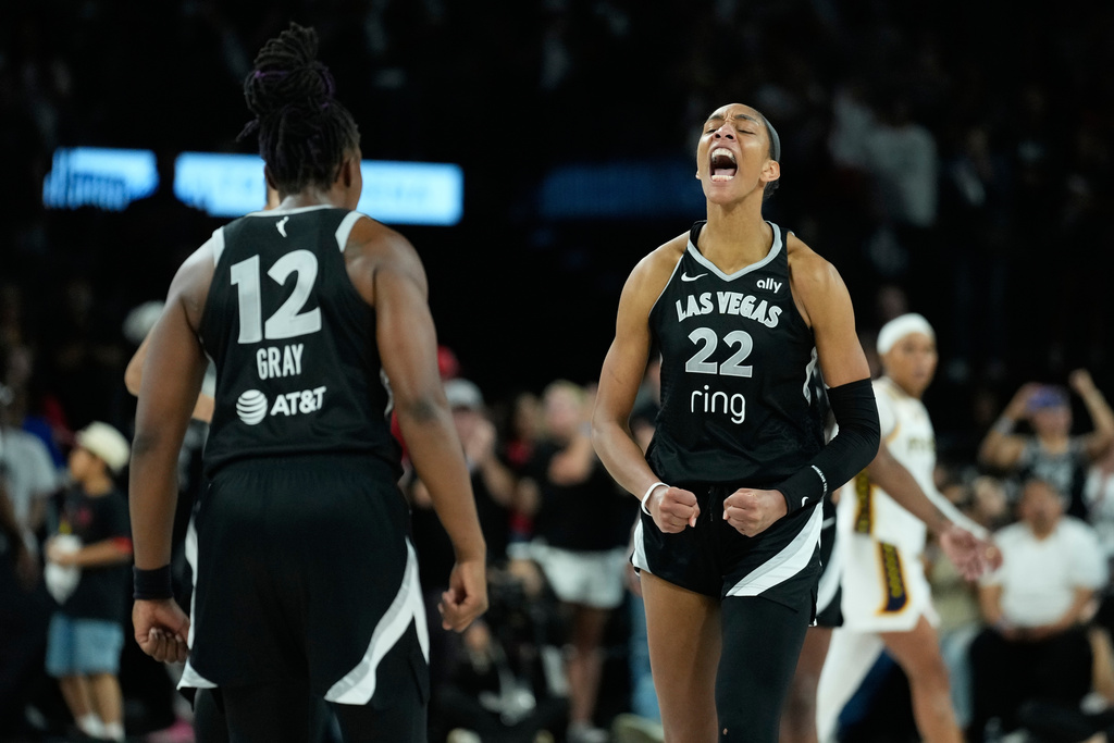 Las Vegas Aces center A'ja Wilson (22) and Las Vegas Aces guard Chelsea Gray (12) celebrate after a play against the Indiana Fever during overtime in Game 5 of a WNBA basketball playoff semifinals series Tuesday, Sept. 30, 2025, in Las Vegas. (AP Photo/John Locher)