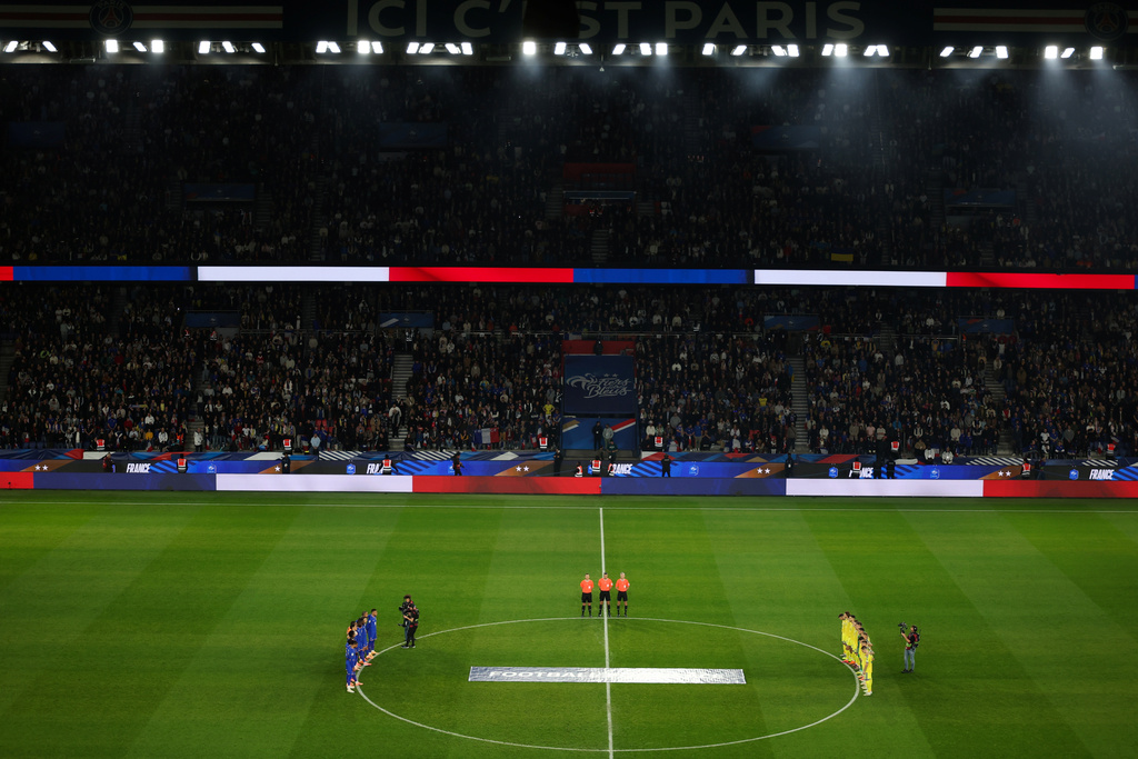 Ukrainian, right, and French players observe a minute of silence in tribute to the victims of the Nov.13, 2015 Paris attacks, ahead of the 2026 World Cup qualifiers Europe zone group D football match between France and Ukraine at the Parc des Princes stadium, Thursday, Nov. 13, 2025 in Paris. ( Franck Fife, Pool photo via AP)