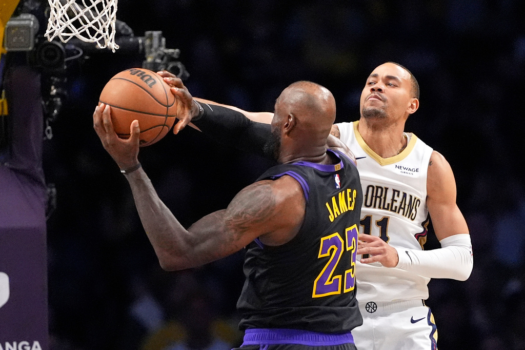Los Angeles Lakers forward LeBron James, left, tries to shoots as New Orleans Pelicans guard Bryce McGowens defends during the first half of an NBA basketball game Tuesday, March 3, 2026, in Los Angeles. (AP Photo/Mark J. Terrill)