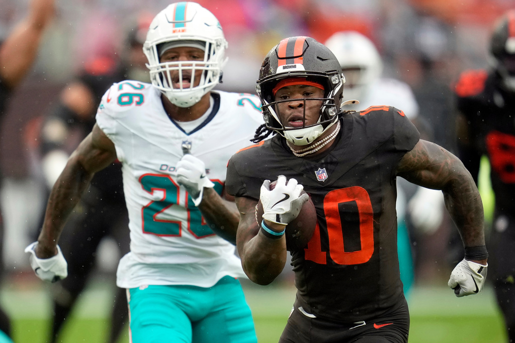 Cleveland Browns running back Quinshon Judkins (10) carries the ball ahead of Miami Dolphins cornerback Rasul Douglas (26) in the first half of an NFL football game in Cleveland, Sunday, Oct. 19, 2025. (AP Photo/Sue Ogrocki)