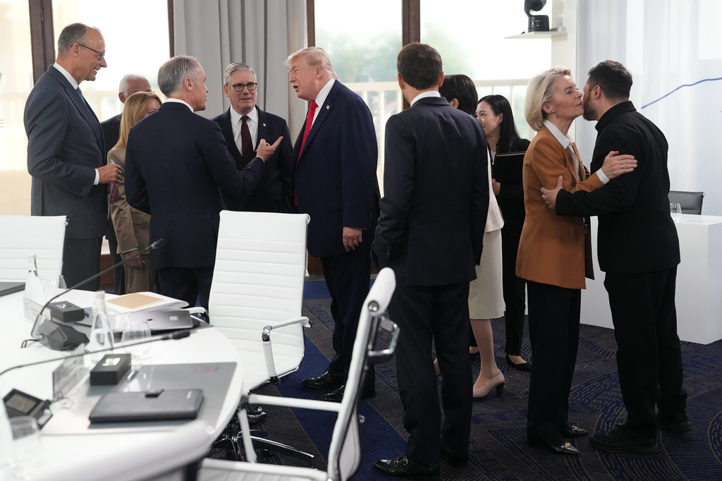 European Commission President Ursula von der Leyen, second right, greets Ukrainian President Volodymyr Zelenskyy, right, as other G7 leaders speak with each other during a working session at the G7 summit in Evian-les-Bains, France, Tuesday, June 16, 2026. (AP Photo/Thibault Camus, Pool)