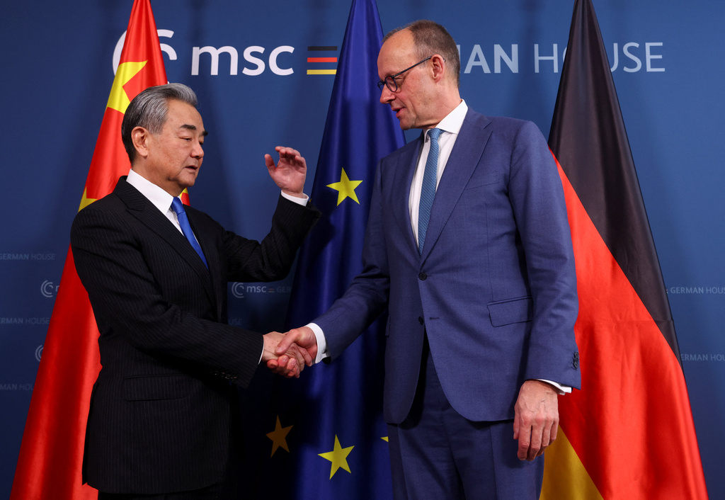 German Chancellor Friedrich Merz, right, shakes hands with Chinese Foreign Minister Wang Yi as they meet during the Munich Security Conference (MSC) in Munich, Germany, Saturday Feb. 14, 2026. (Thilo Schmuelgen/Pool Photo via AP)