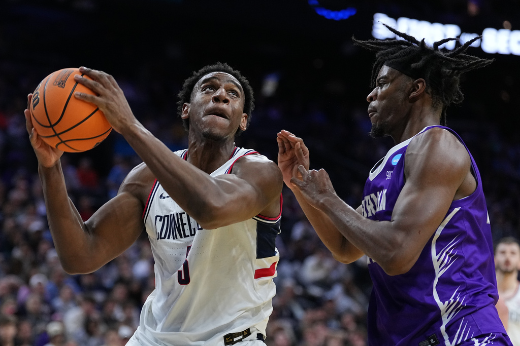 UConn's Tarris Reed Jr., left, goes up to shoot against Furman's Cooper Bowser during the first half in the first round of the NCAA college basketball tournament, Friday, March 20, 2026, in Philadelphia. (AP Photo/Matt Rourke)
