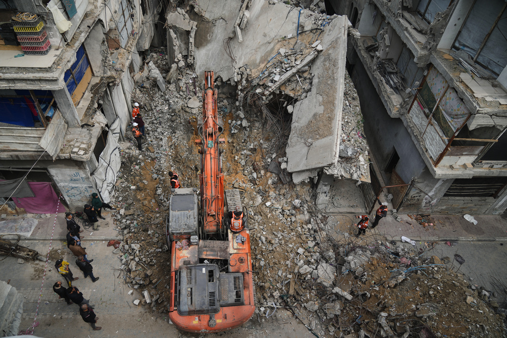 Gaza's civil defense teams work to recover the remains of members of the Abu Nada family, who remain trapped beneath the rubble of their four-story house after it was destroyed by an Israeli airstrike in December 2023, in Gaza City, Monday, Feb. 9, 2026. (AP Photo/Jehad Alshrafi)