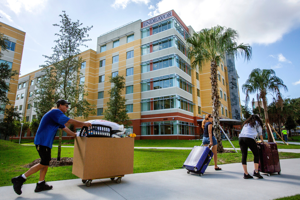FILE - University of South Florida students walk with suitcases toward a dorm in Tampa on Aug. 16, 2018. (Bronte Wittpenn/Tampa Bay Times via AP)