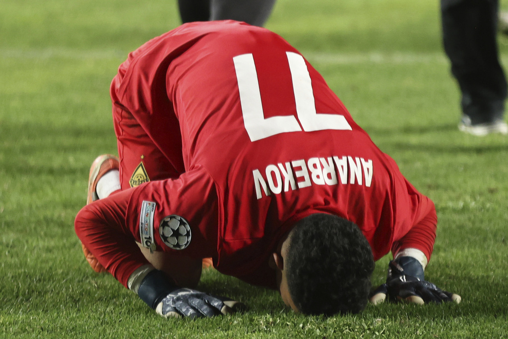 Kairat's goalkeeper Temirlan Anarbekov kisses the grass after winning the Champions League playoff second leg soccer match between Kairat and Celtic at Ortalyk stadium in Almaty, Kazakhstan, Wednesday, Aug. 27, 2025. (AP Photo/Alikhan Sariyev)