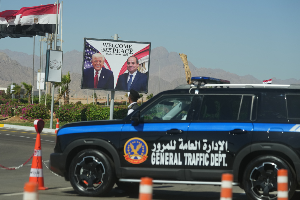 A police vehicle in front of a poster showing Egyptian President Abdel-Fattah el-Sissi and U.S. President Donald Trump at the Red Sea city of Sharm el-Sheikh, Egypt, Monday, Oct. 13, 2025. (AP Photo/Amr Nabil)