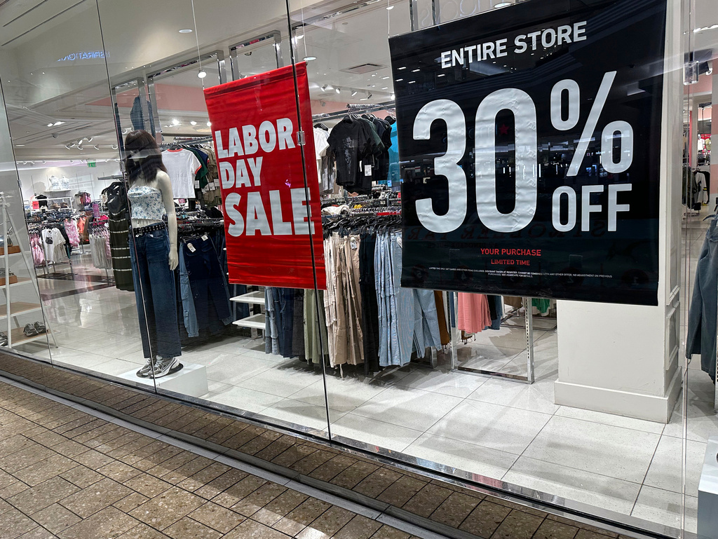 FILE - Signs announce a Labor Day sale in the window of a clothing store at a mall in Denver on Aug. 21, 2024. (AP Photo/David Zalubowski, File)