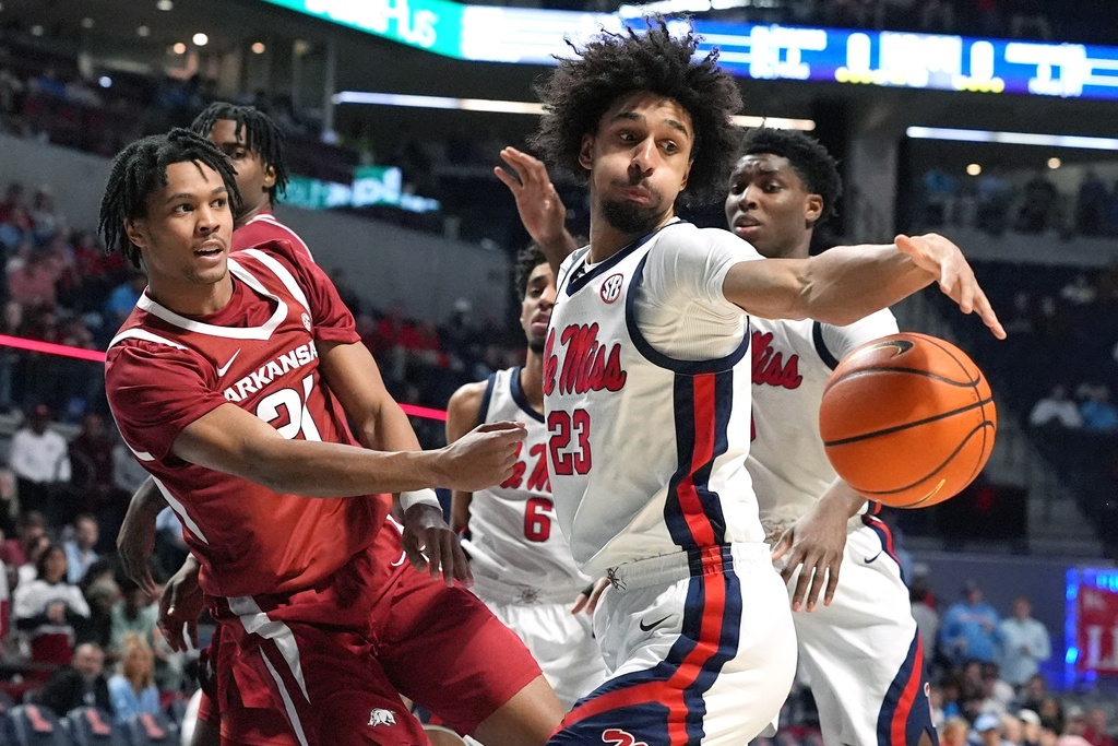 Arkansas guard D.J. Wagner (21) passes the ball past Mississippi guard Patton Pinkins (23) during the first half of an NCAA college basketball game, Wednesday, Jan. 7, 2026, in Oxford, Miss. (AP Photo/Rogelio V. Solis)